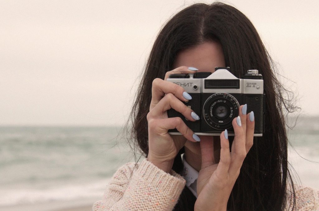 Woman with camera photographing in morning.