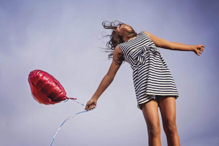Joyful woman, happily jumping with heart balloon.